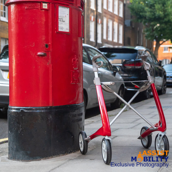 A red byACRE Ultralight Rollator next to a British post box