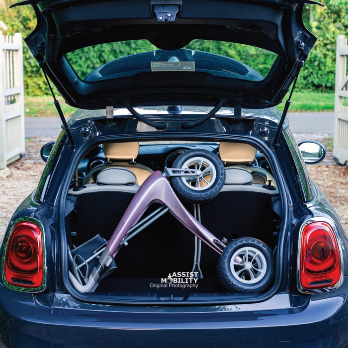 The compact folded Rose Gold byACRE Carbon Overland rollator in the boot of a dark blue Mini Cooper