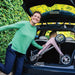 Happy lady showing off the Pale Rose byACRE Carbon Ultralight rollator folded neatly in a small car boot
