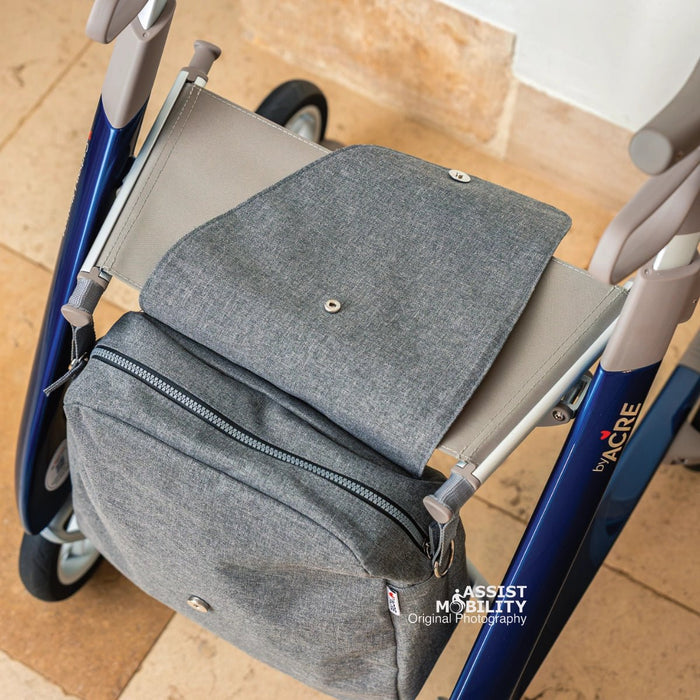 Overhead view of the grey byACRE Weekend Bag, its flap folded over the seat of a blue byACRE rollator