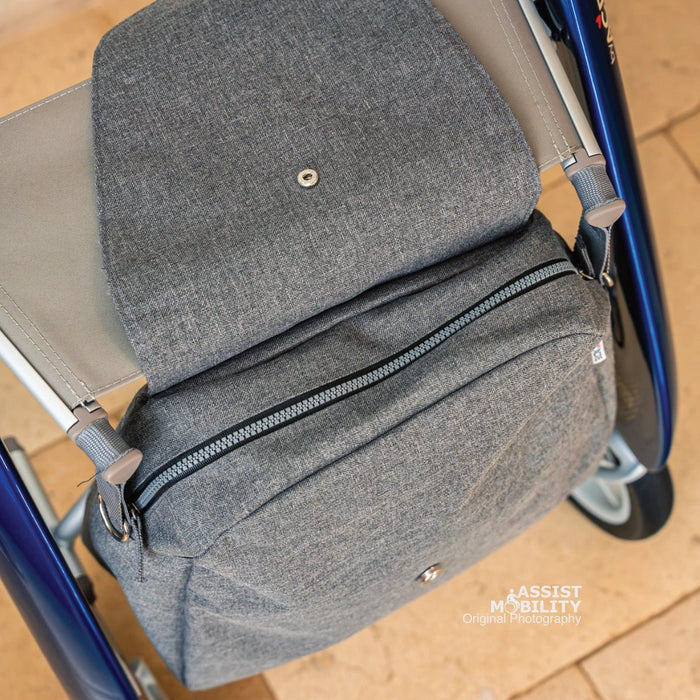 Close-up of the grey byACRE Weekend Bag with its zip, flap and snap fastener, attached under the seat of a blue byACRE rollator