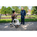 Lady sat on Drive AeroWalk rollator in a park speaking to a gentleman