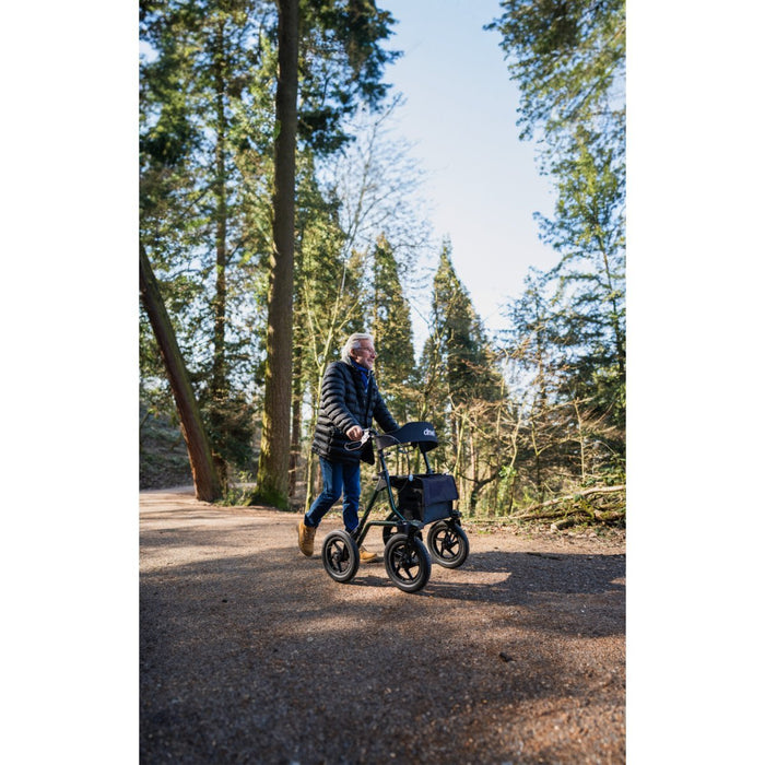 Man walking through the woods with Torrow rollator