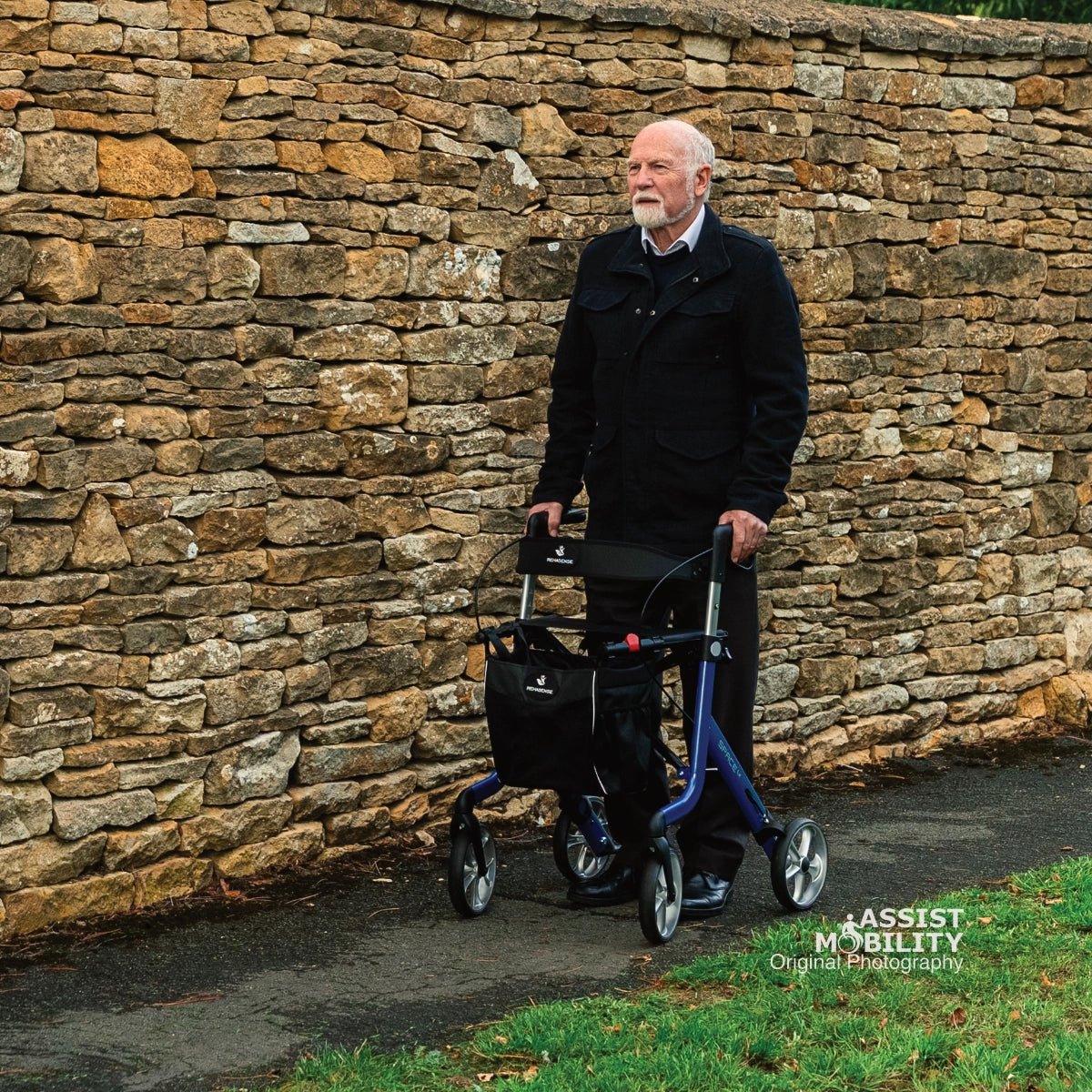 Older man out walking with the Electric Blue Rehasense Space LX rollator in front of a dry stone wall