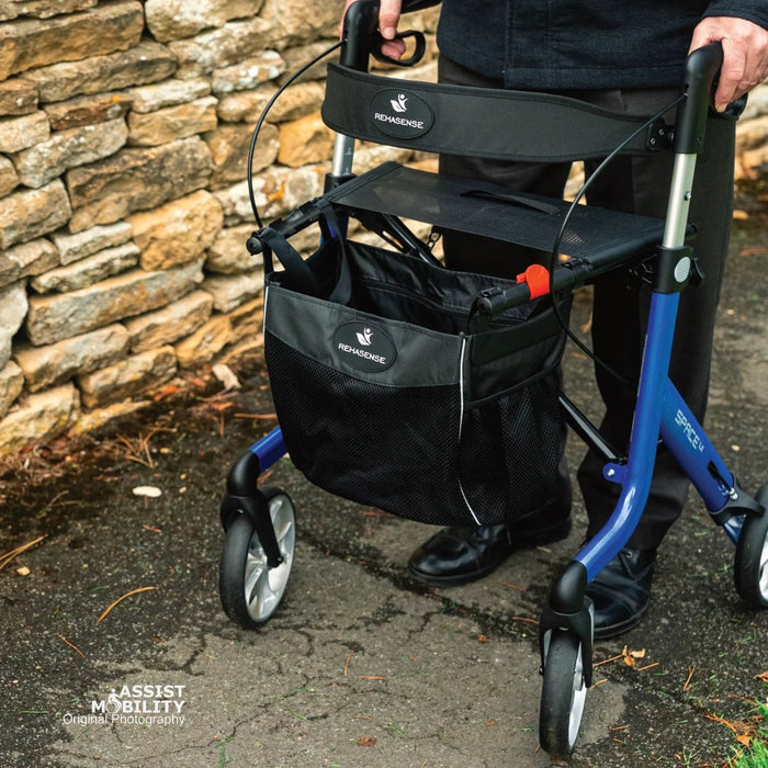 Close-up of the Electric Blue Rehasense Space LX rollator being pushed, showing the padded backrest, seat and Rehasense storage bag