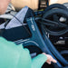 Over-the-shoulder view of a woman loading the folded Rollz Air Carbon Fibre rollator into a car, showing the frame and Rollz logo
