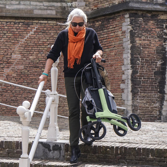 Lady lifting the Rollz Air Rollator in Mint Green down some stairs