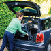Smiling woman easily loading the lightweight Rollz Air Carbon Fibre rollator into a small car boot