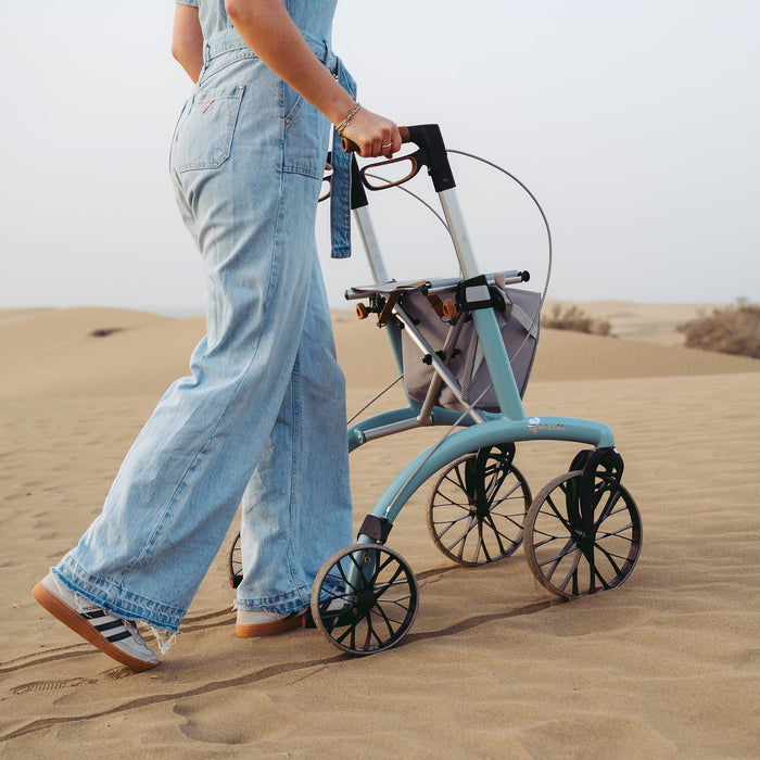 Saljol Allround Rollator Superlight Ice Blue rollator being pushed on the sand