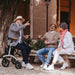 Three people enjoying a chat together.  One gentleman sitting on his Saljol ALU rollator.