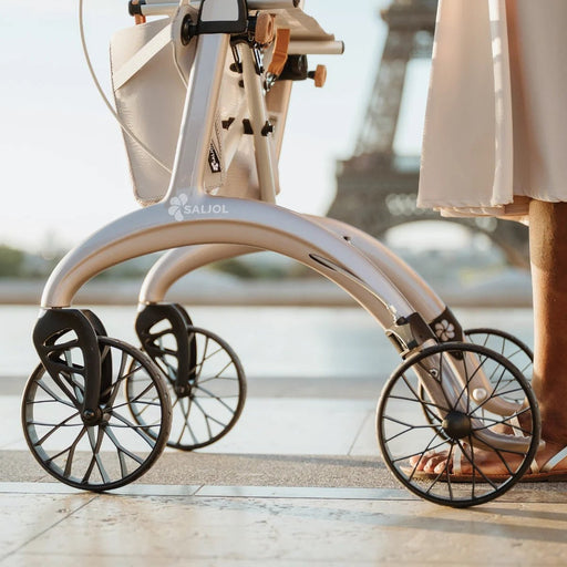Low close-up of the wheels and frame of a Saljol Carbon Superlight rollator in Paris, with the Eiffel Tower in the background
