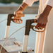 Close-up of both hands gripping the ergonomic handles and brake levers of the Saljol Carbon Superlight rollator
