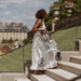 Woman easily carrying the folded lightweight Saljol Carbon Superlight rollator up stone steps in a Paris park