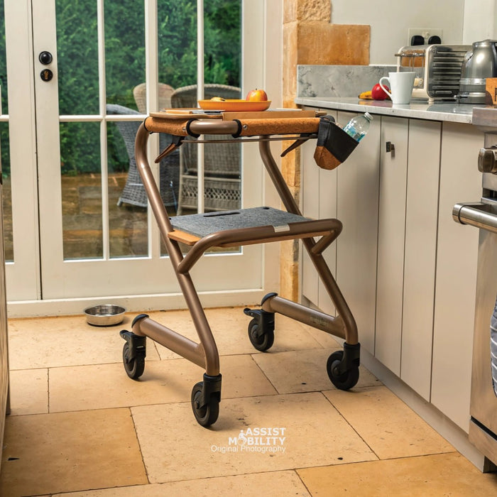 The Saljol Page indoor rollator in the kitchen with fruit and plate on the tray. 