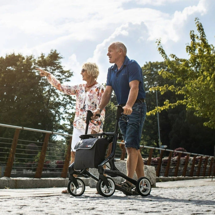 Couple out for a walk along the river bank with the Topro Pegasus rollator in black