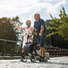 Couple out for a walk along the river bank with the Topro Pegasus rollator in black