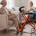 Two ladies sitting in a living room on comfy seating having a chat with a Lets Dream rollator in Sunset