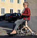 Lady sitting comfortably on the Trust Care Lets Fly rollator taking a rest.