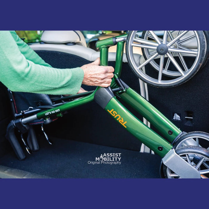 The green Trust Care Let's Go Out outdoor rollator in the boot of a car 