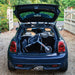 Trust Care Let's Shop shopping rollator folded with its bag in the boot of a dark blue Mini Cooper