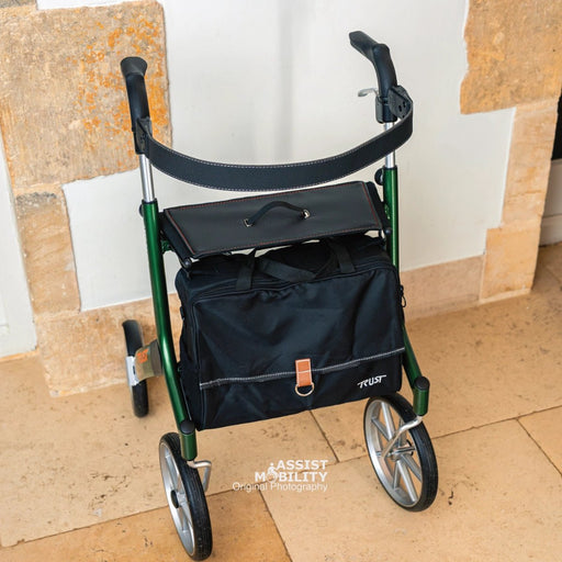 Trust Care Let's Go Out rollator in British Racing Green with the padded backrest fitted, shown with its seat and bag on a patio