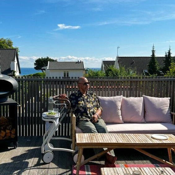 Gentelman sitting enjoying the sun on the patio with his The scandinavian Butler indoor rollator from byACRE..