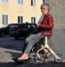 Lady sitting comfortably on the Trust Care Lets Fly rollator taking a rest.