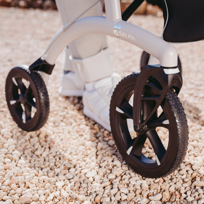 Close up of the tough wheels being used on gravel making the Saljol ALU rollator  a great all round rollator.  Touch and dependable for any use.
